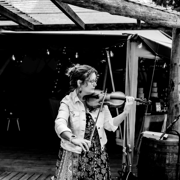 Sarah performing violin at an outdoor tipi wedding, black and white